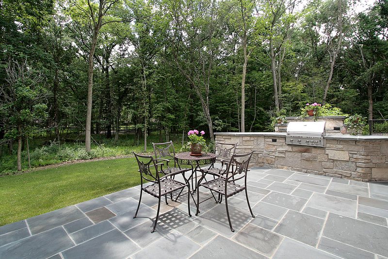 blue-stone-masonry-backyard-patio-and-grill-built-into-stone-wall